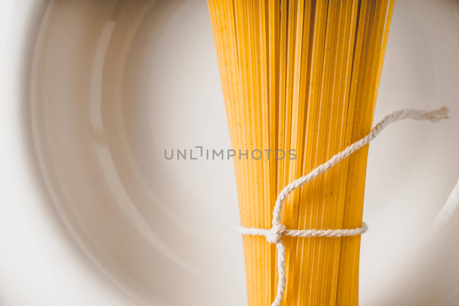 Raw spaghetti  on the white plate close-up