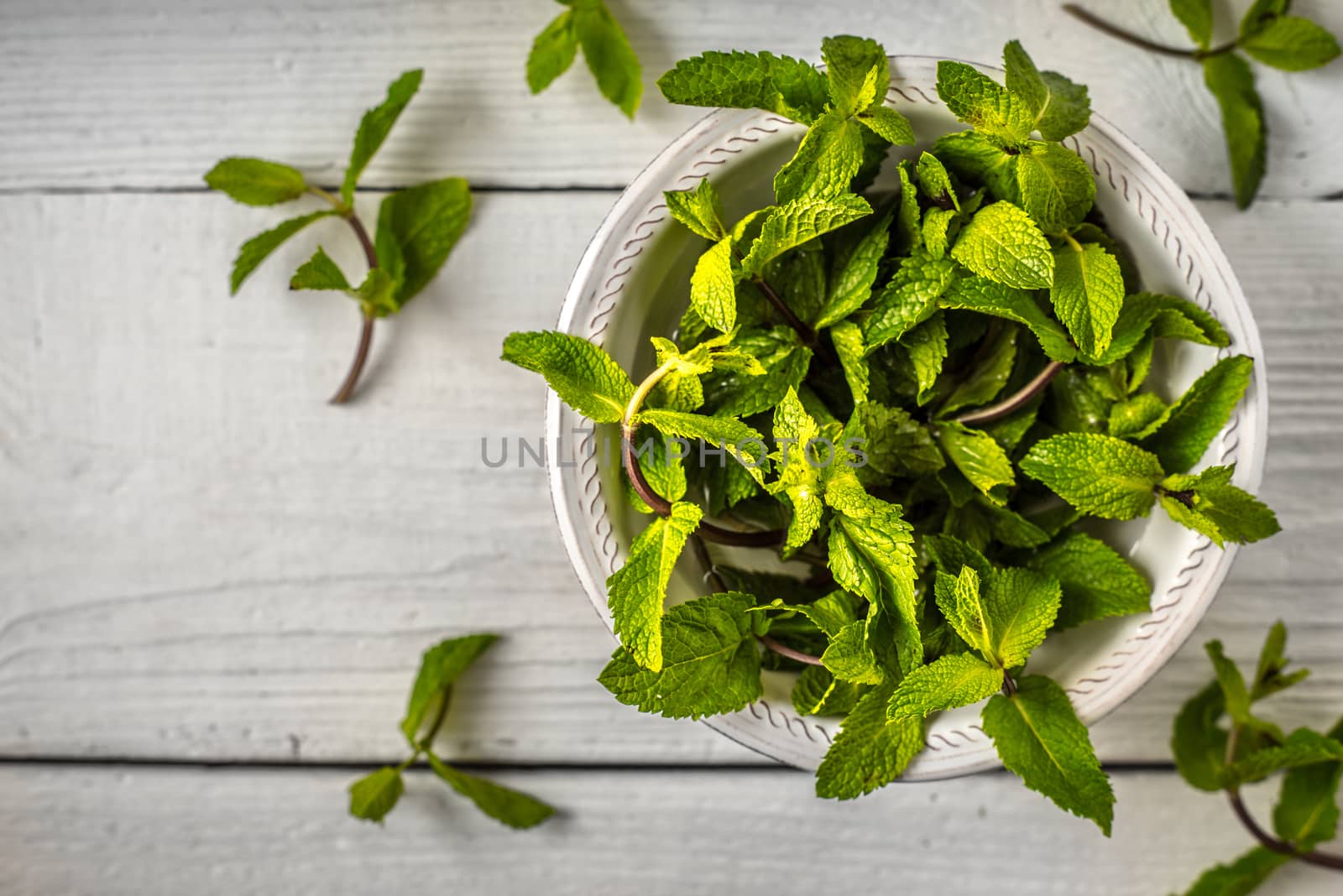 Composition of the mint leaves on the white wooden table top view