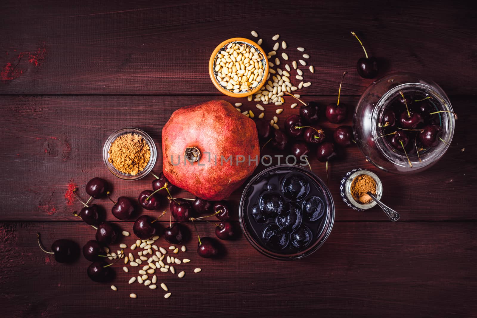 Still life with pomegranate , cherry and spices on the red wooden table. Concept of oriental fruits top view by Deniskarpenkov