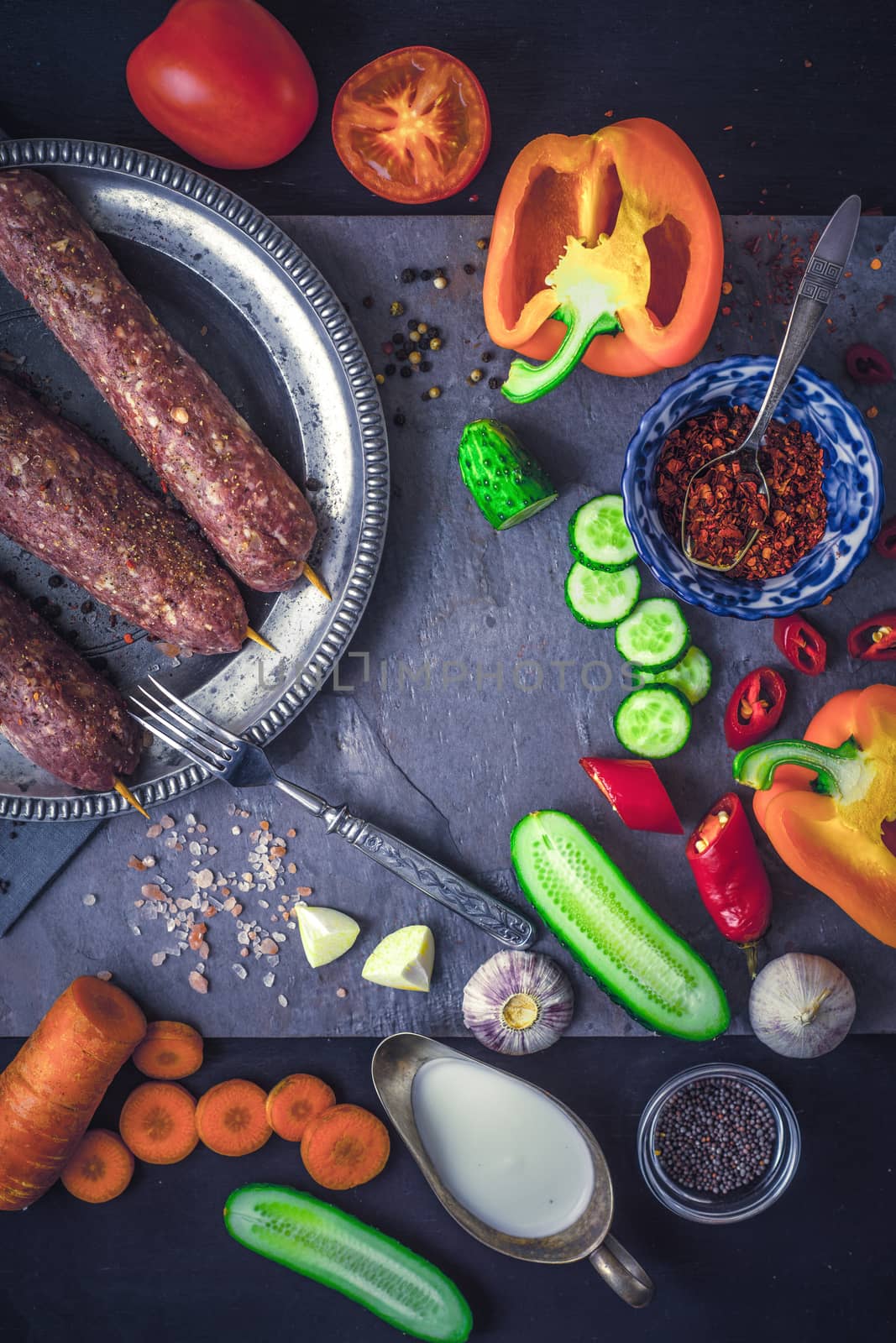 Kebabs with seasoning and vegetable. Concept Middle east , Asian and Caucasian cuisine vertical by Deniskarpenkov