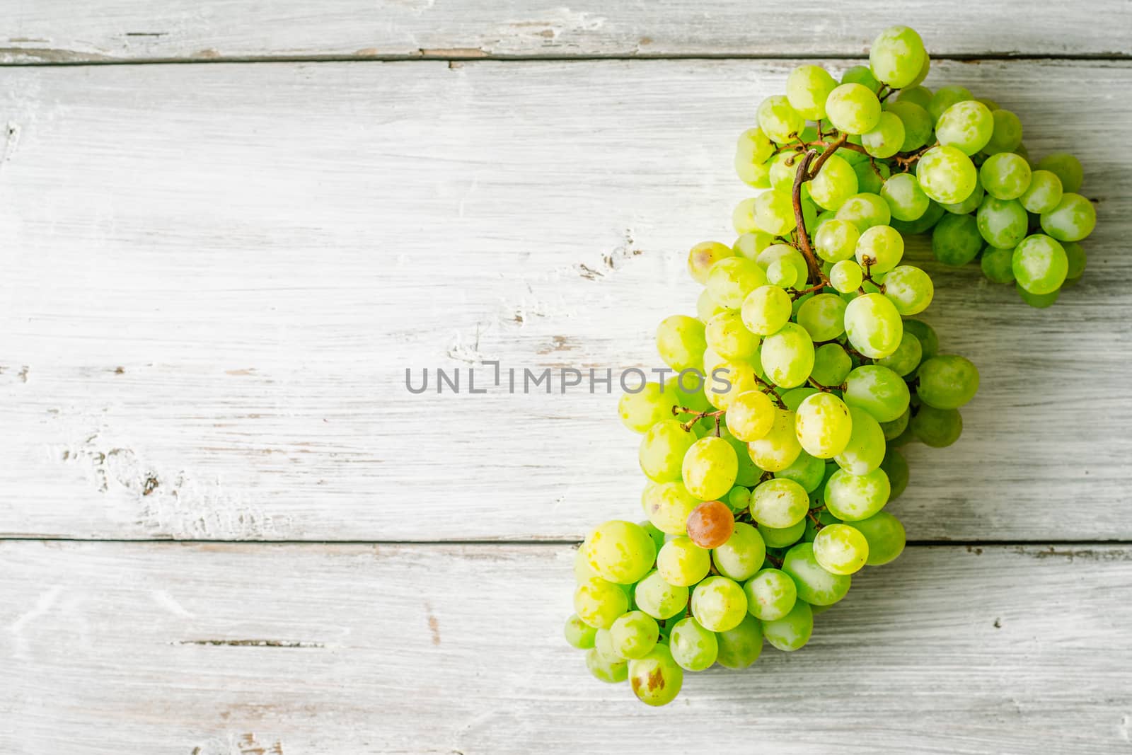 Grapes on the white wooden table top view