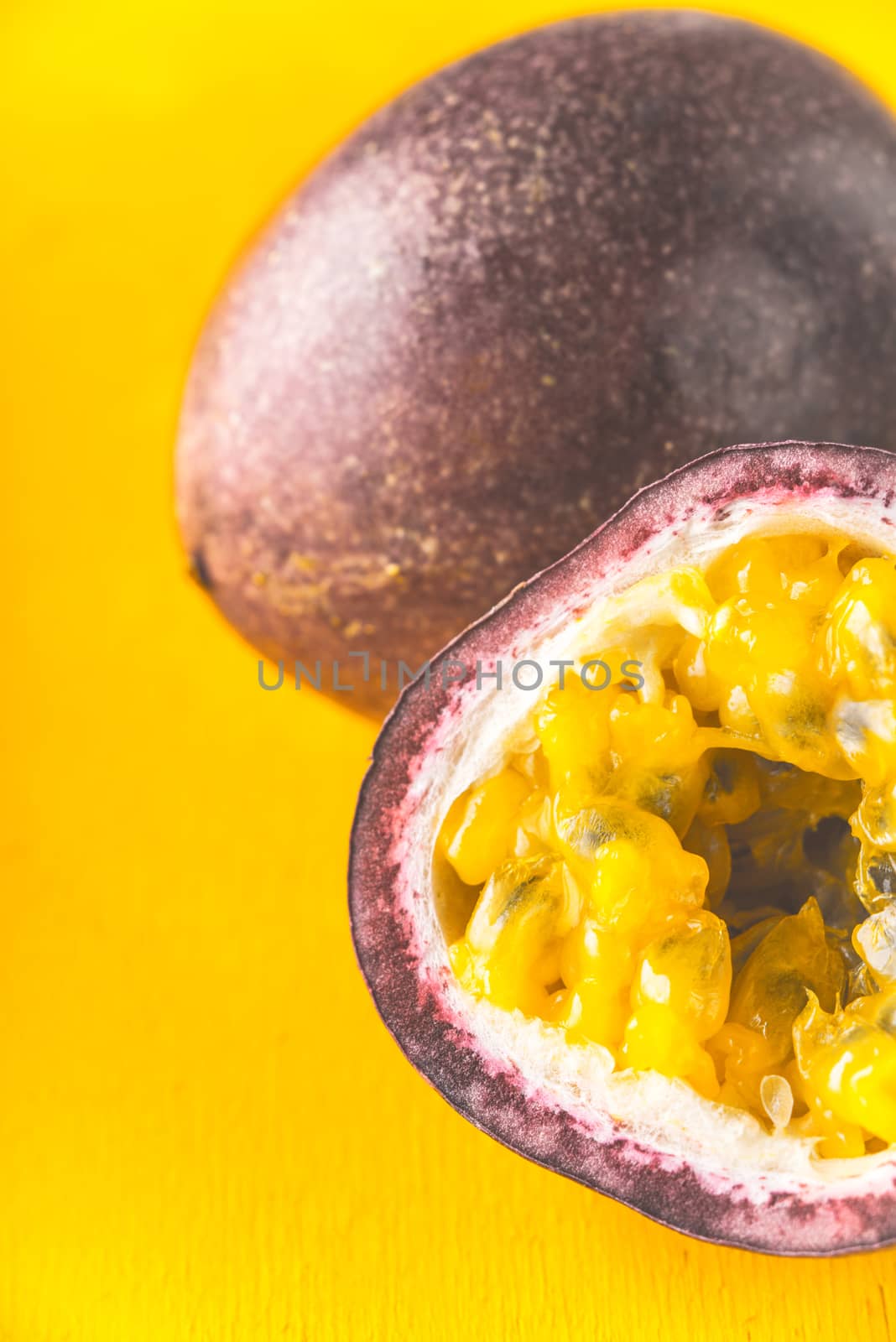 Passion fruit on the yellow background vertical by Deniskarpenkov