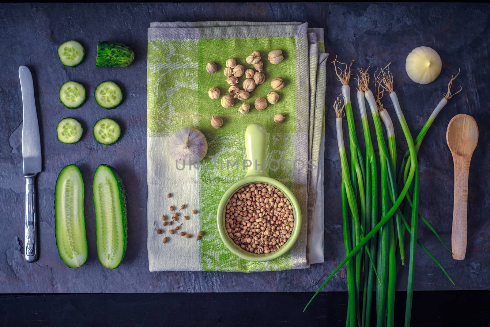 Green vegetables with seasoning on the dark stone background top view by Deniskarpenkov