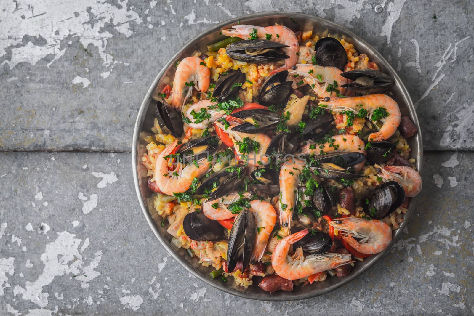 Paella in the metal plate on the metal background top view by Deniskarpenkov