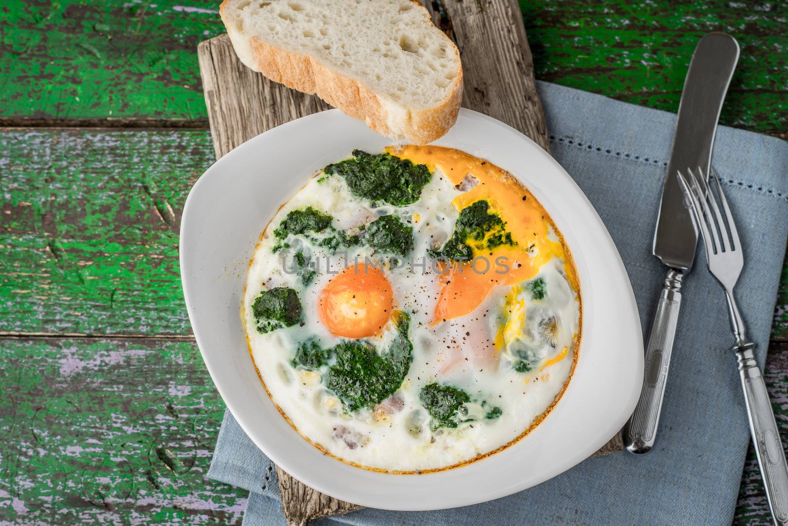 Florentine eggs with pureed spinach on the old wooden board