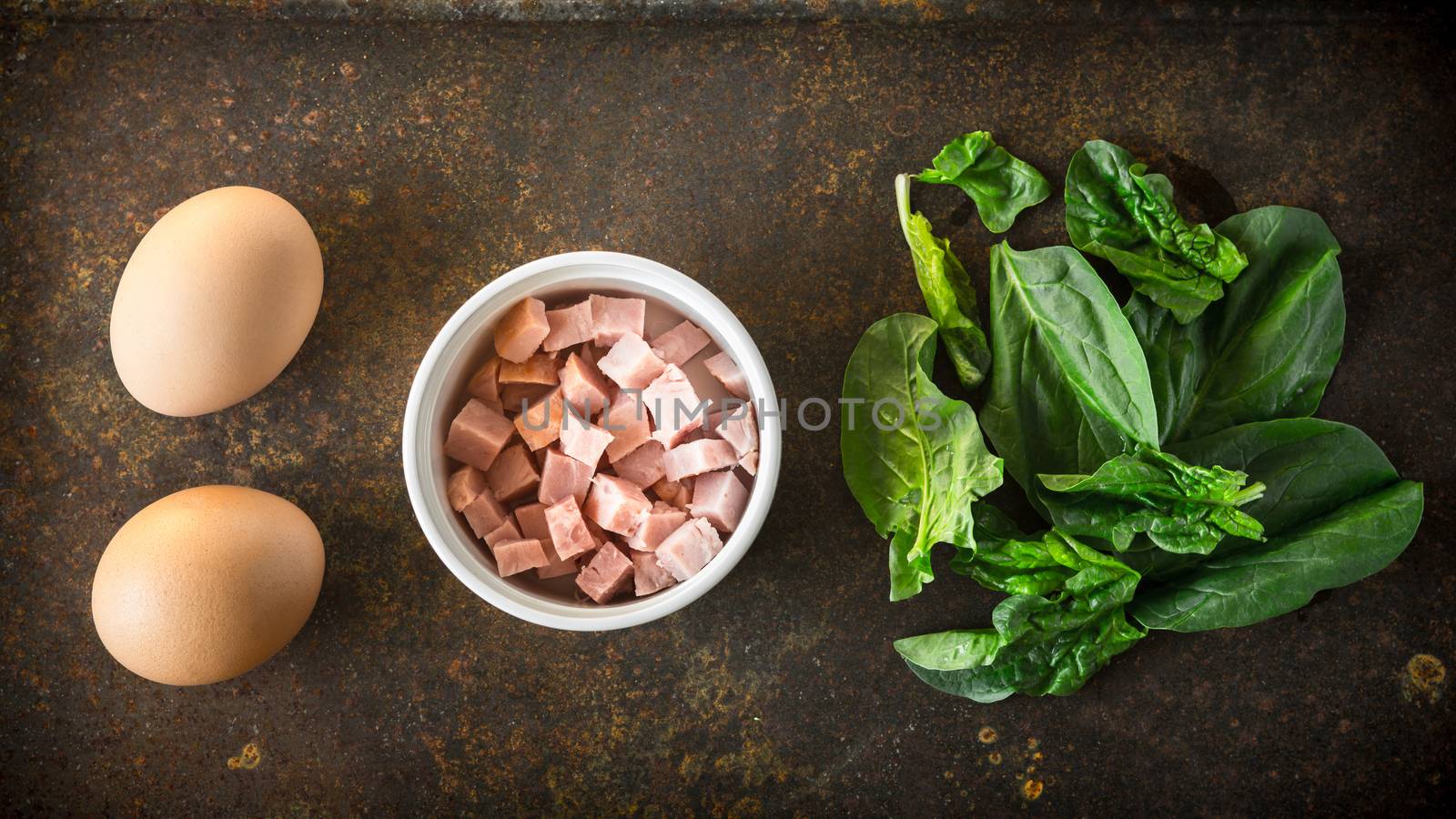 Ingredients for Florentine eggs with spinach on the rusty background by Deniskarpenkov
