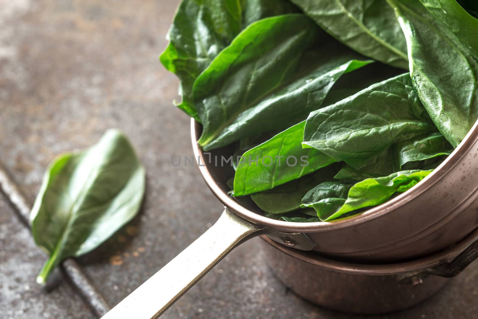 Fresh spinach in the copper pot by Deniskarpenkov