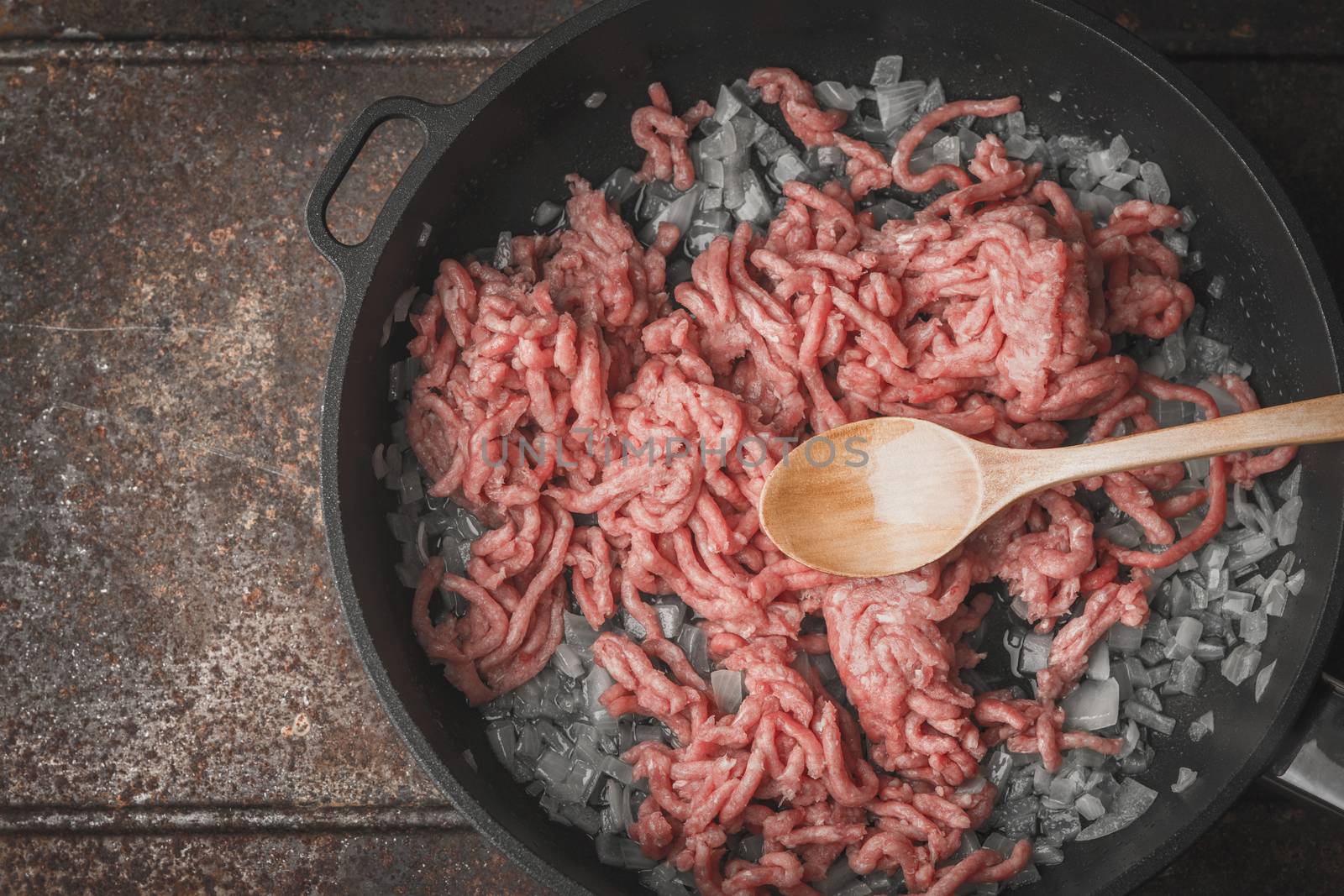 Raw minced meat with sliced onion in the pan top view