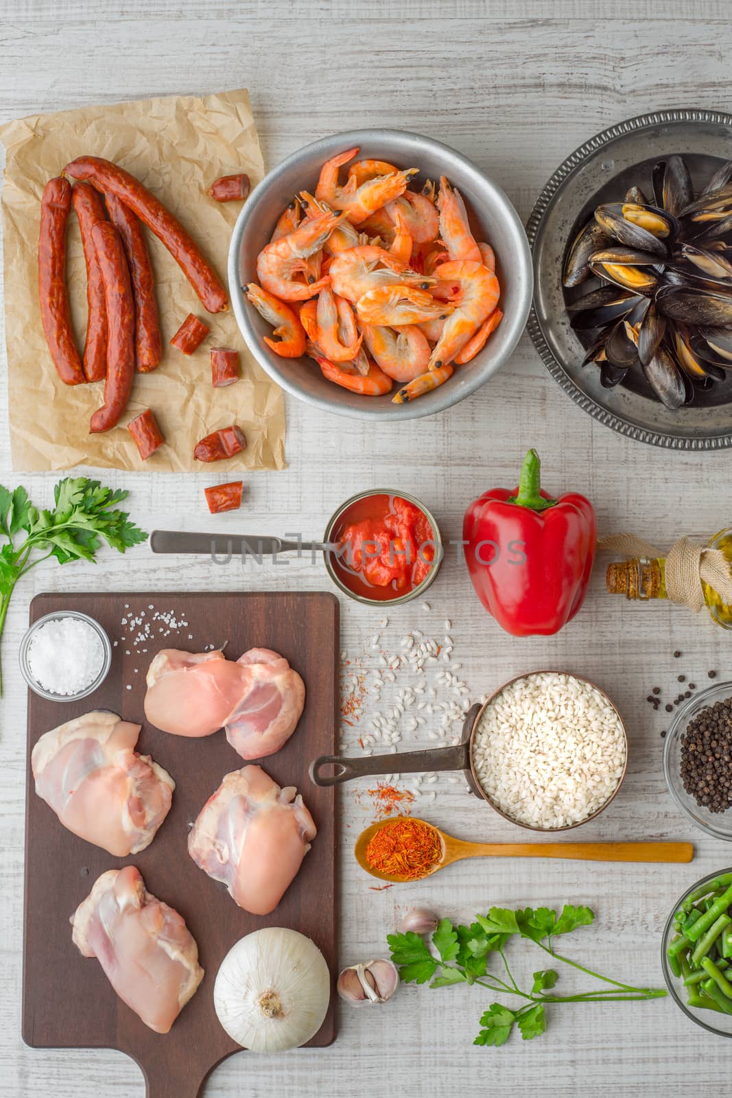 Ingredients for paella on the white  table vertical by Deniskarpenkov