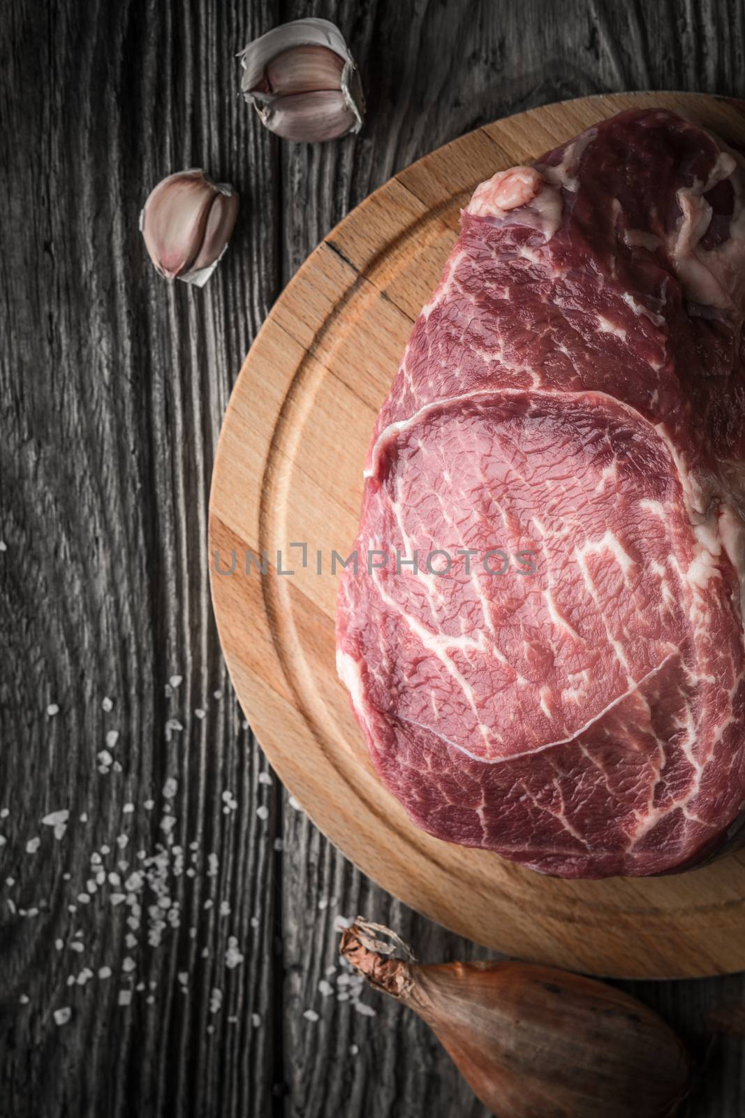 Raw angus beef  with seasoning on the wooden table vertical