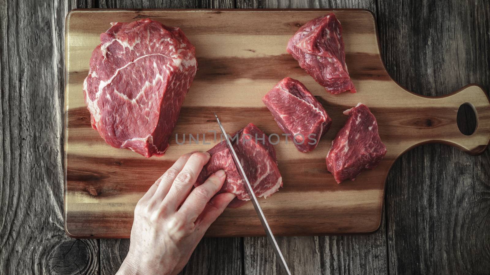 Cutting angus beef on the wooden table top view by Deniskarpenkov