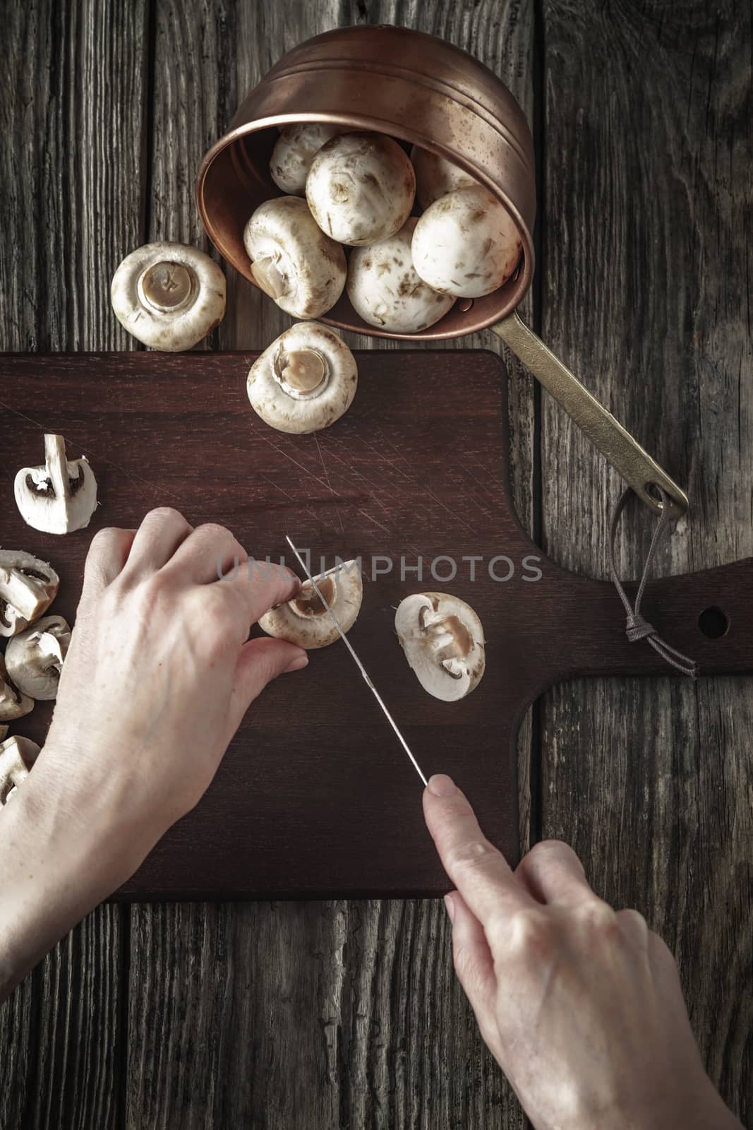 Cutting mushrooms on the wooden board vertical by Deniskarpenkov