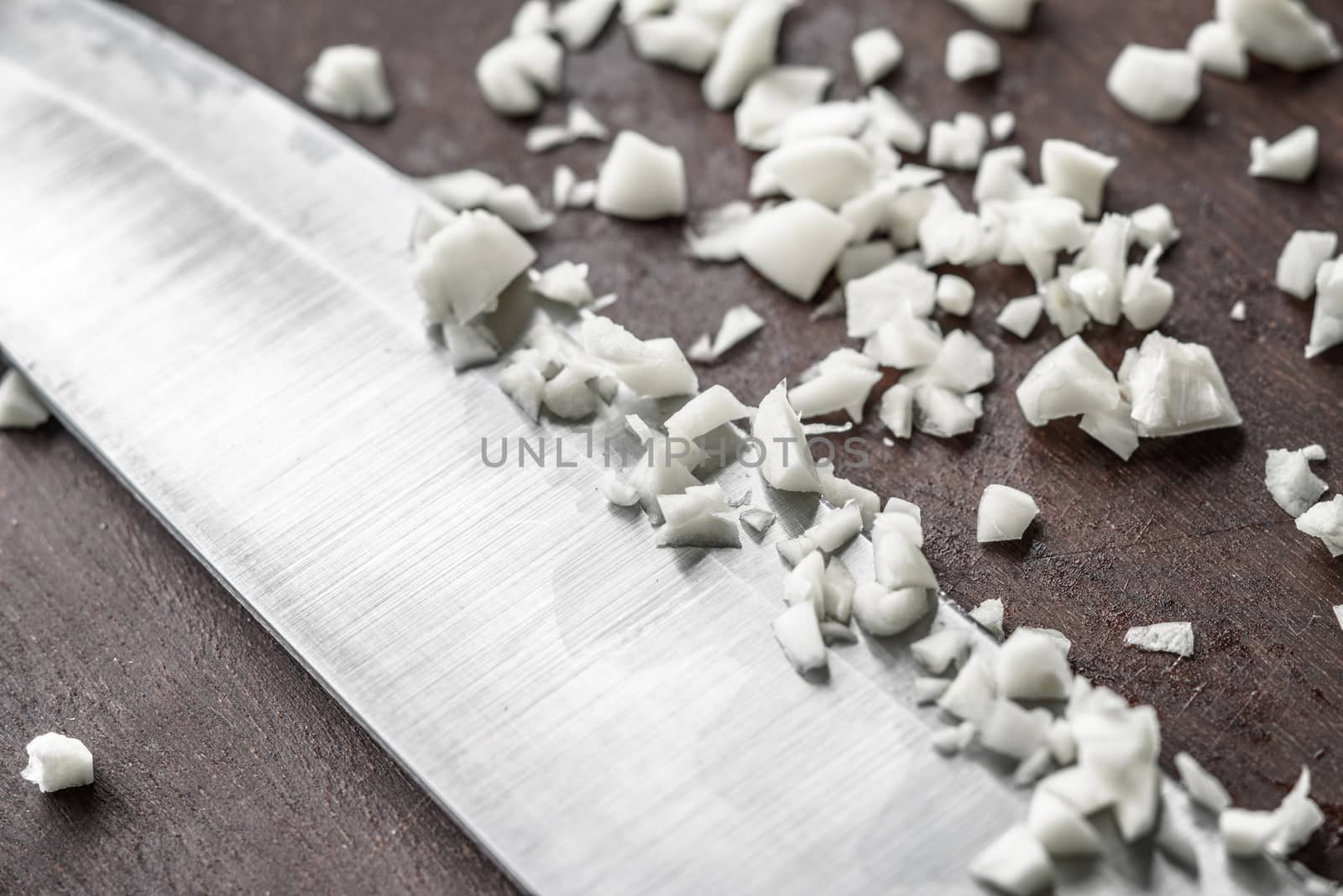 Chopped onion with knife on the wooden board