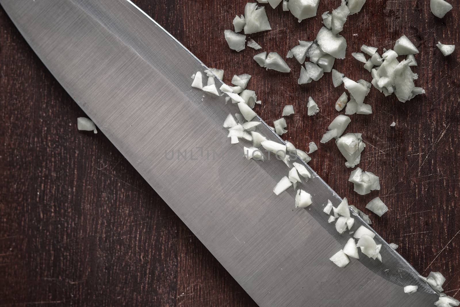 Chopped onion with knife on the wooden board top view by Deniskarpenkov