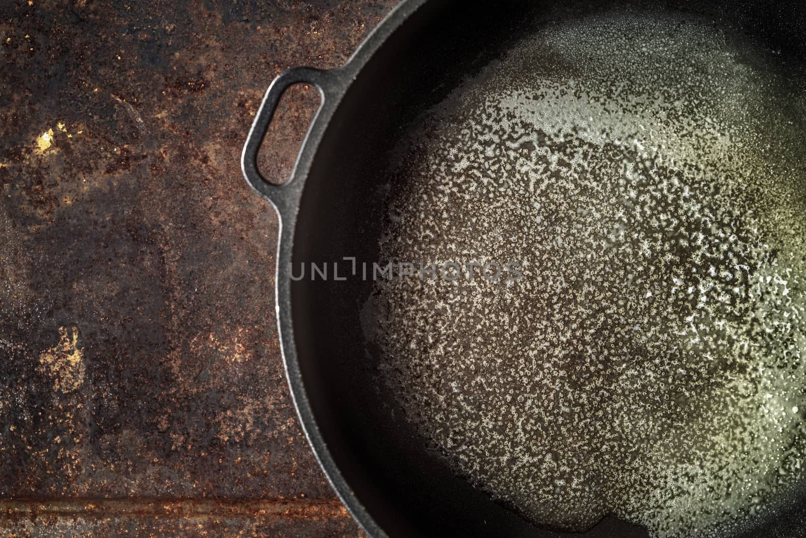 Pan with melted butter on the metal background top view by Deniskarpenkov