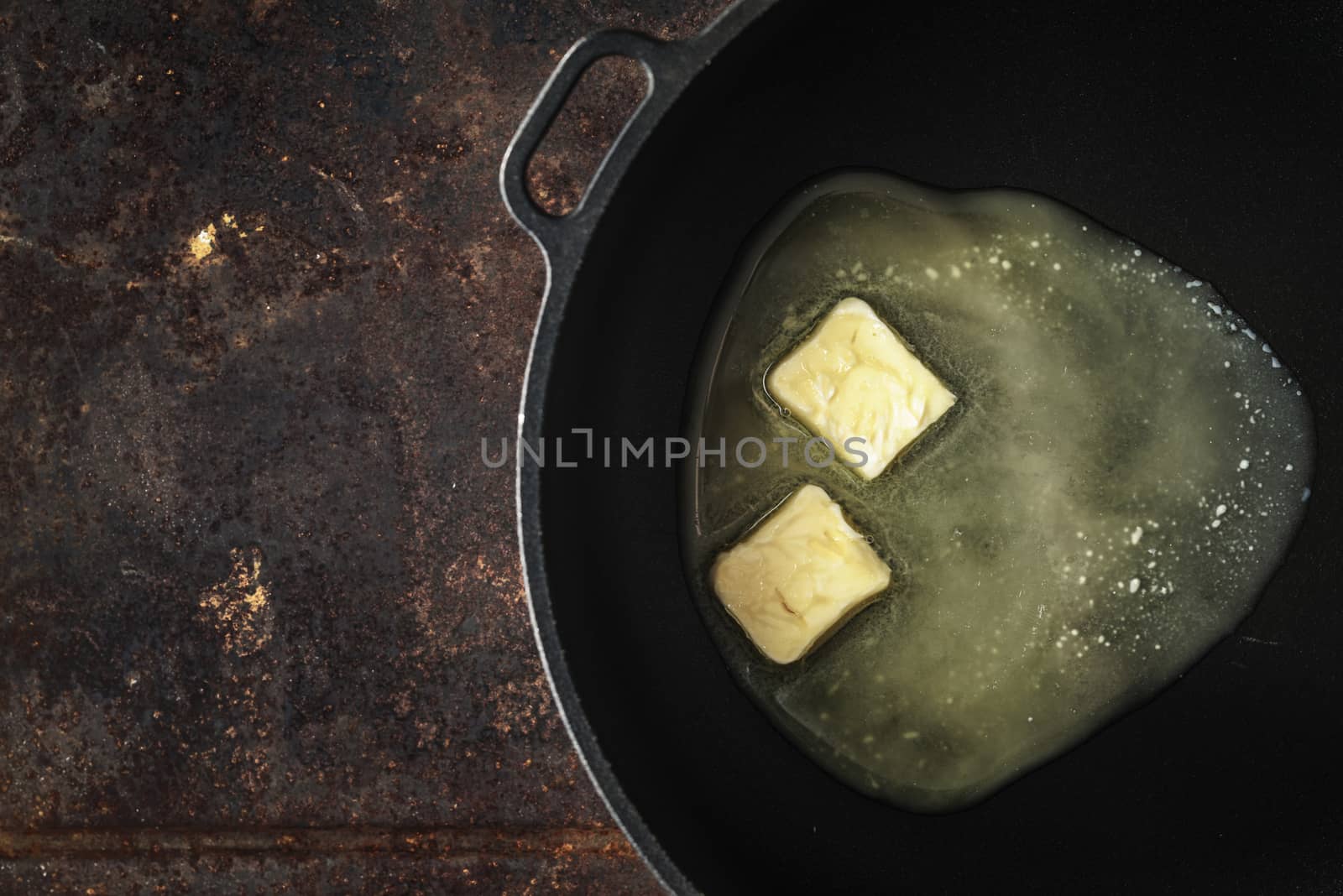 Pieces of butter in the hot pan top view by Deniskarpenkov