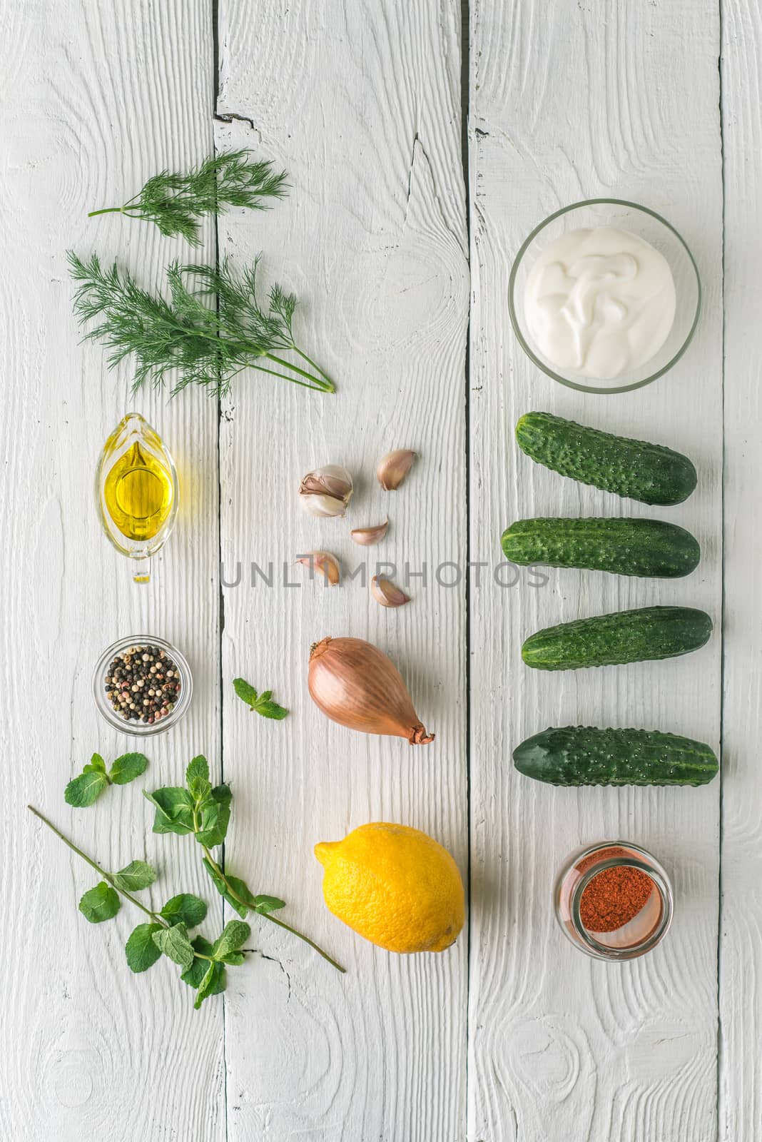 Ingredients for tzatziki on the white wooden table vertical by Deniskarpenkov