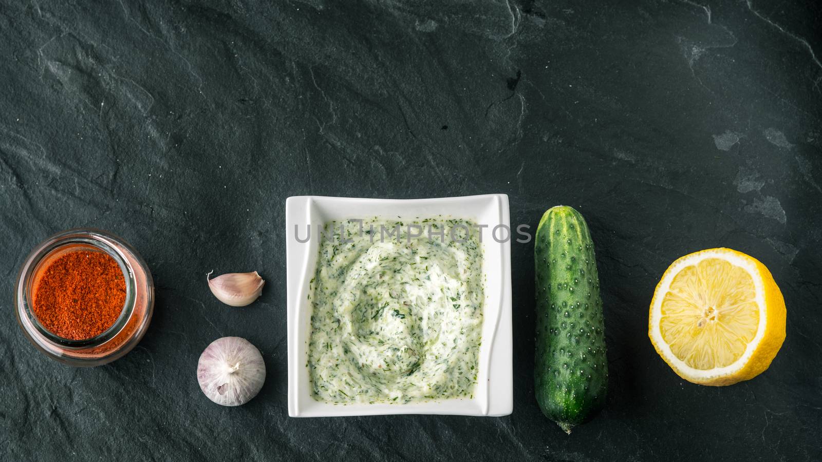 Tzatziki  on the stone table with cucumber , lemon and seasoning wide screen by Deniskarpenkov