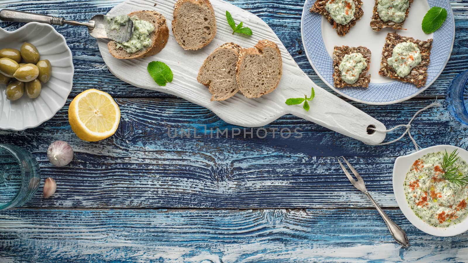 Bread with tzatziki on the blue wooden table with accessorize horizontal