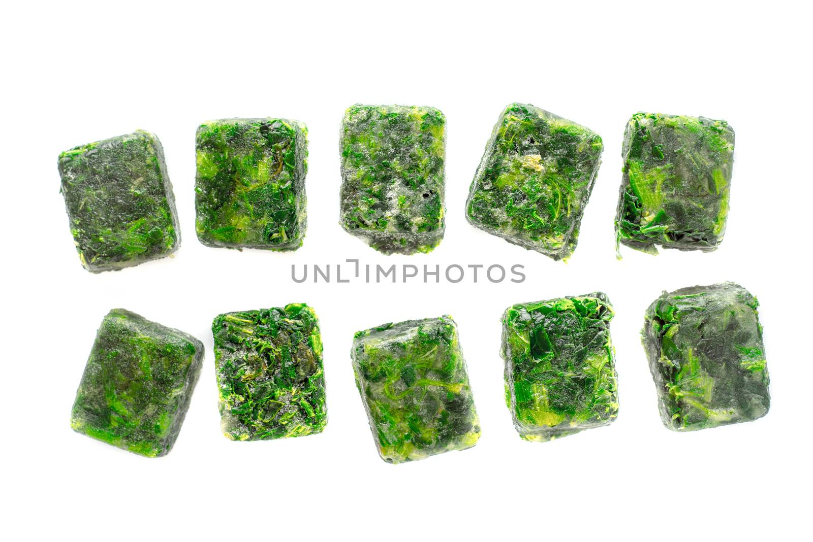 Cubes of frozen spinach on the white background by Deniskarpenkov