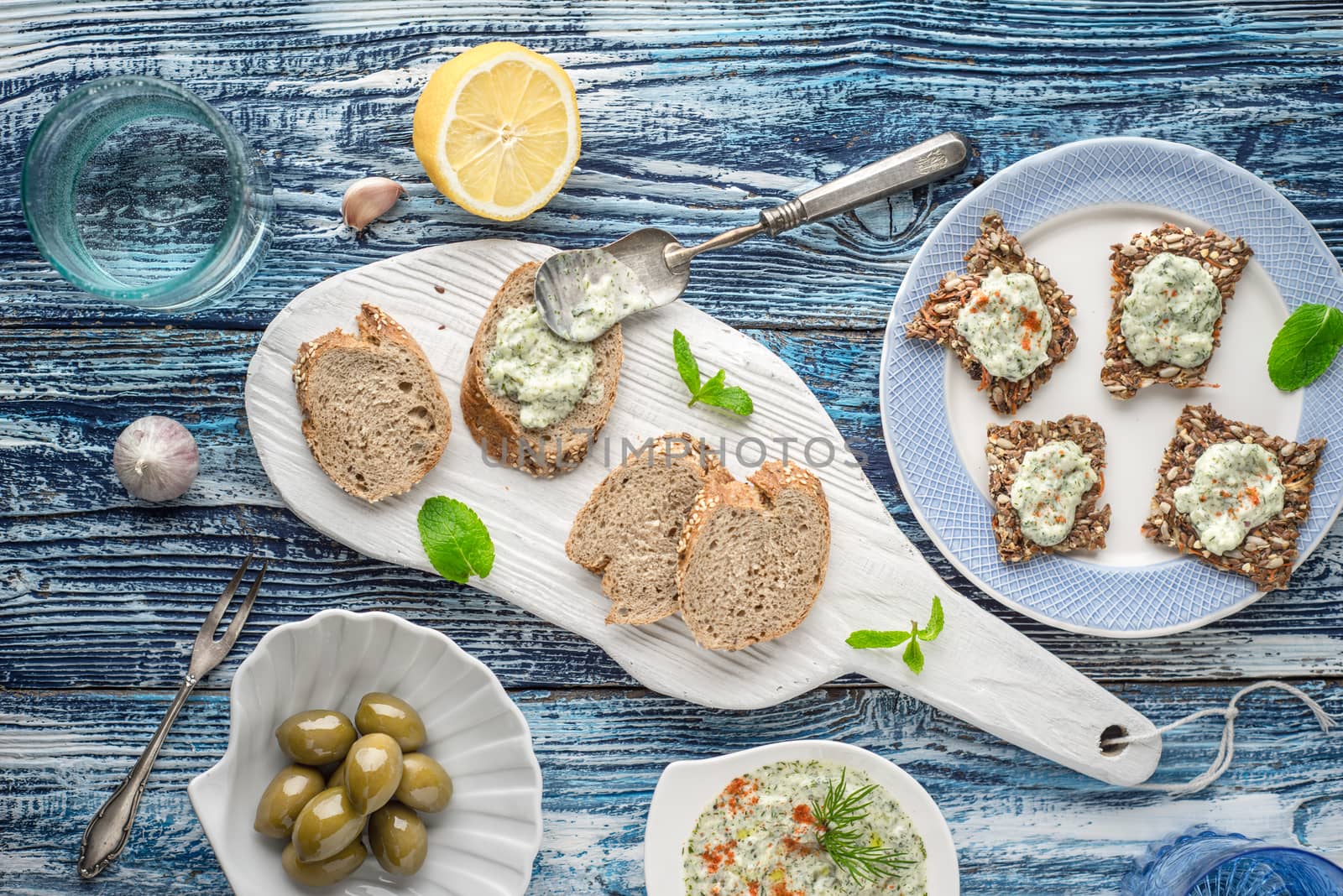 Bread with tzatziki on the blue wooden table with accessorize top view