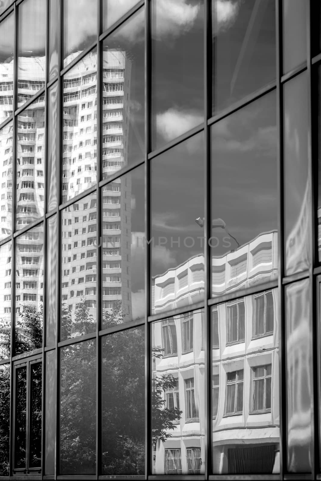 Reflection in the windows of another building black and white vertical by Deniskarpenkov