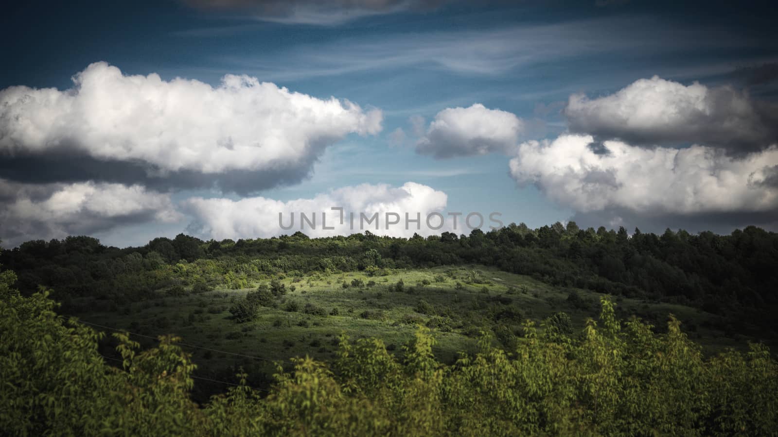 Green hills  under the cloudy sky by Deniskarpenkov