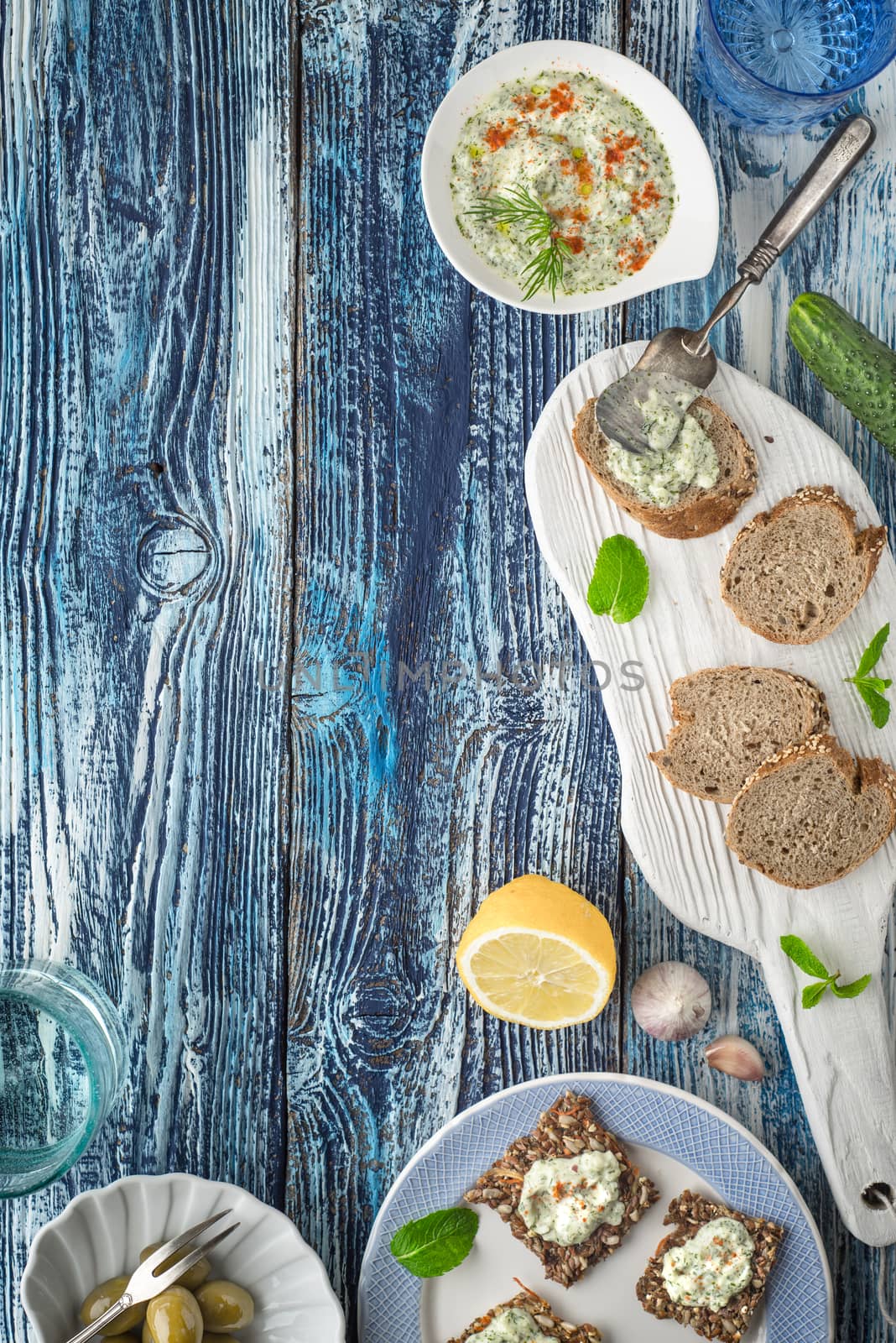 Bread with tzatziki on the blue wooden table with accessorize vertical