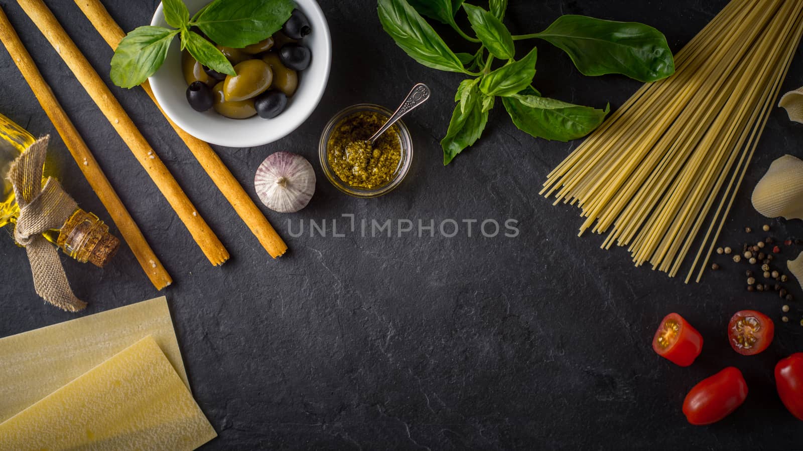 Set of Italian food on the black stone table wide screen by Deniskarpenkov