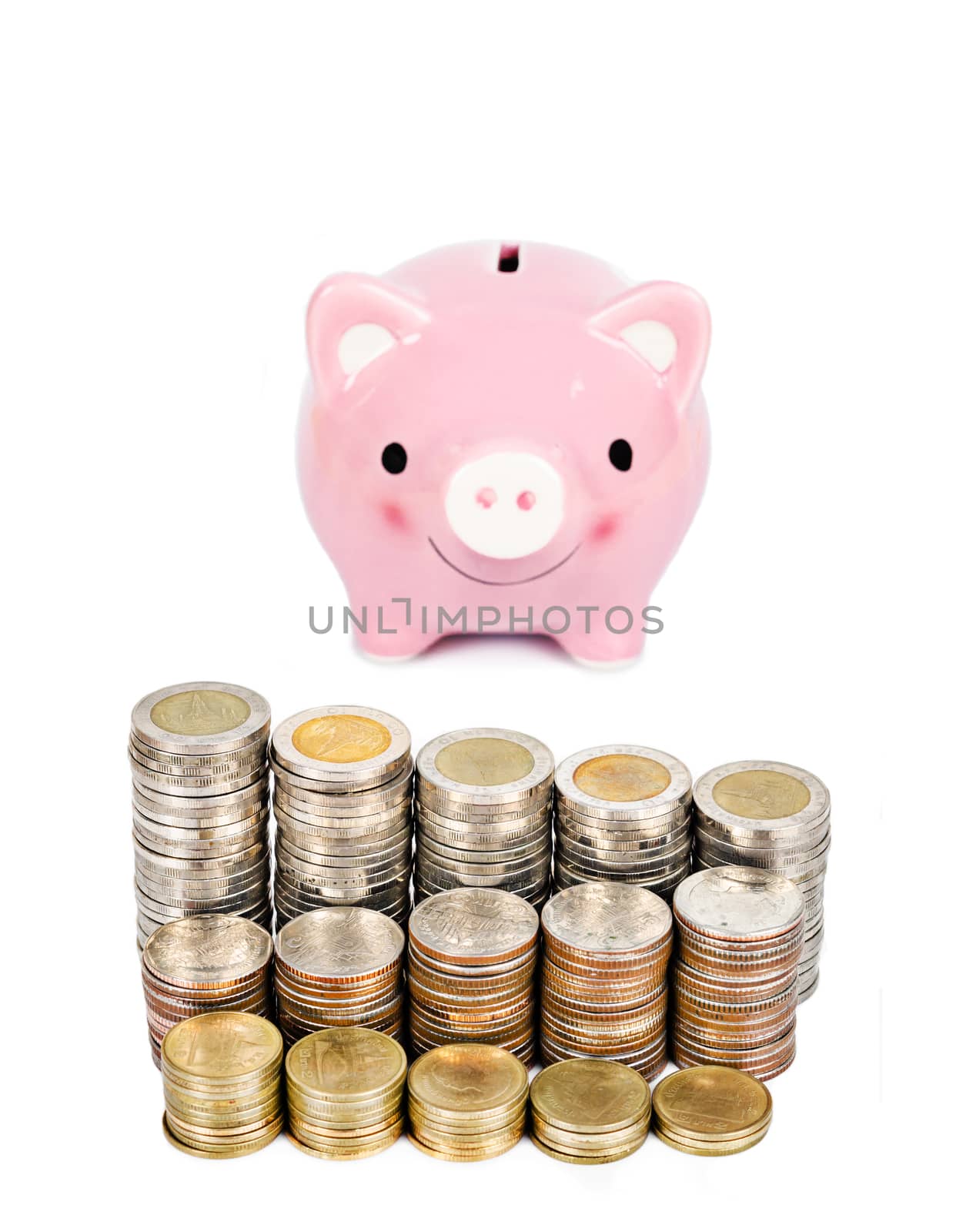 Money coins tower and pink piggybank isolated on white background.