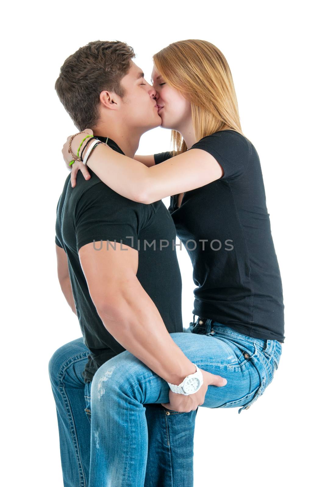 Strong young man holding his lover while kissing her.