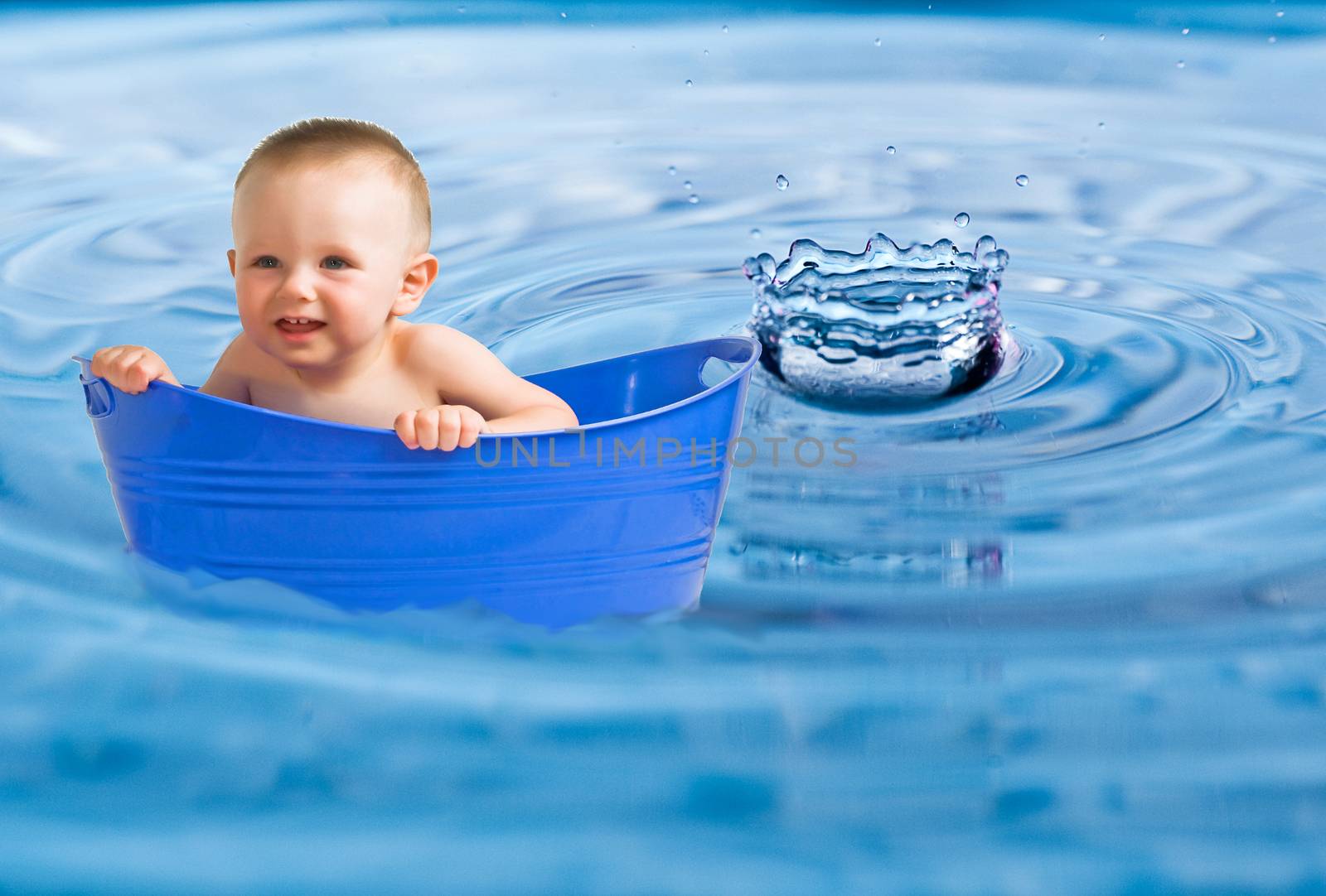 Baby in a plastic tub placed in water-drop photo