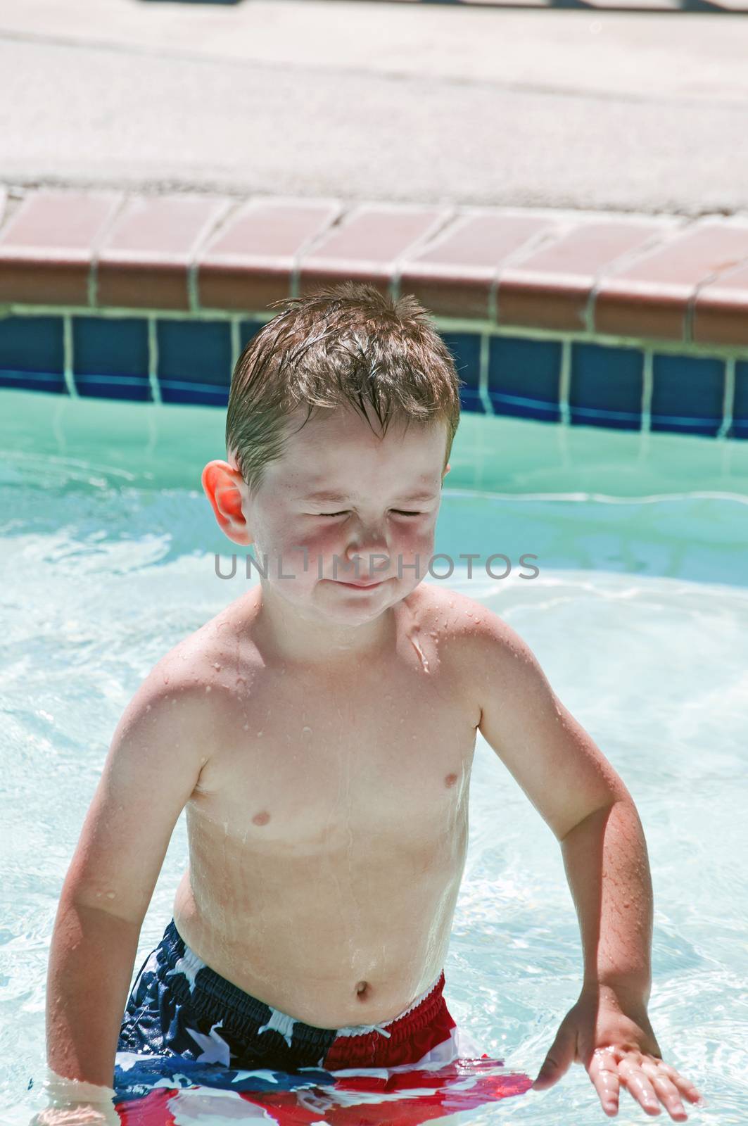 Little boy with irratated eyes in swimming pool