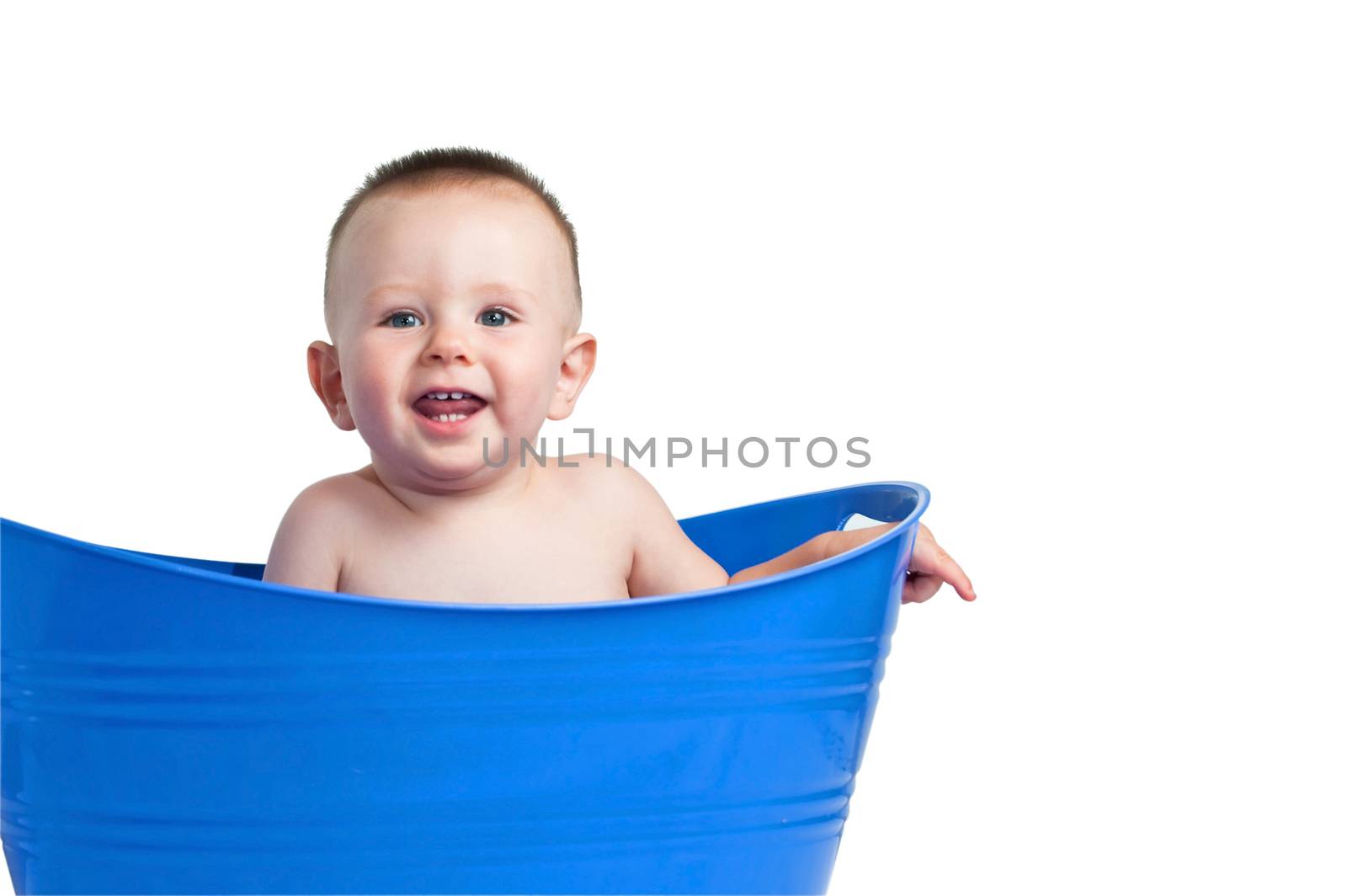 A cute baby boy playing in a blue plastic laundry basket
