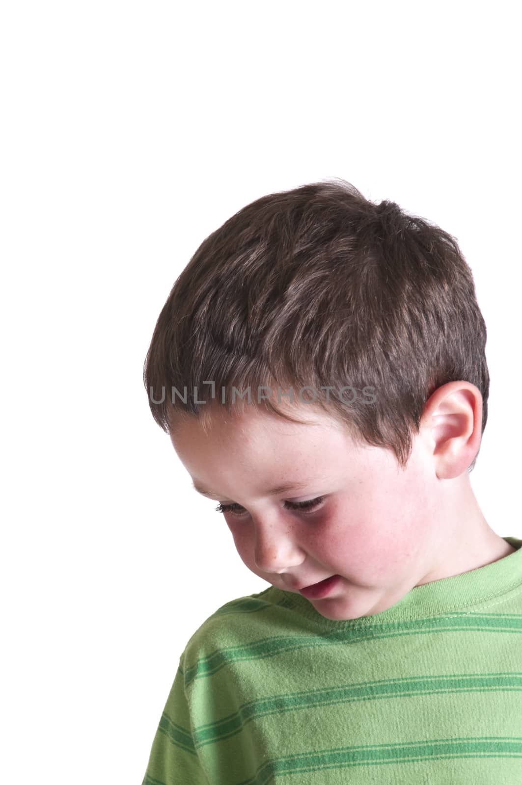 Little boy with his attention towards the floor isolated on white.