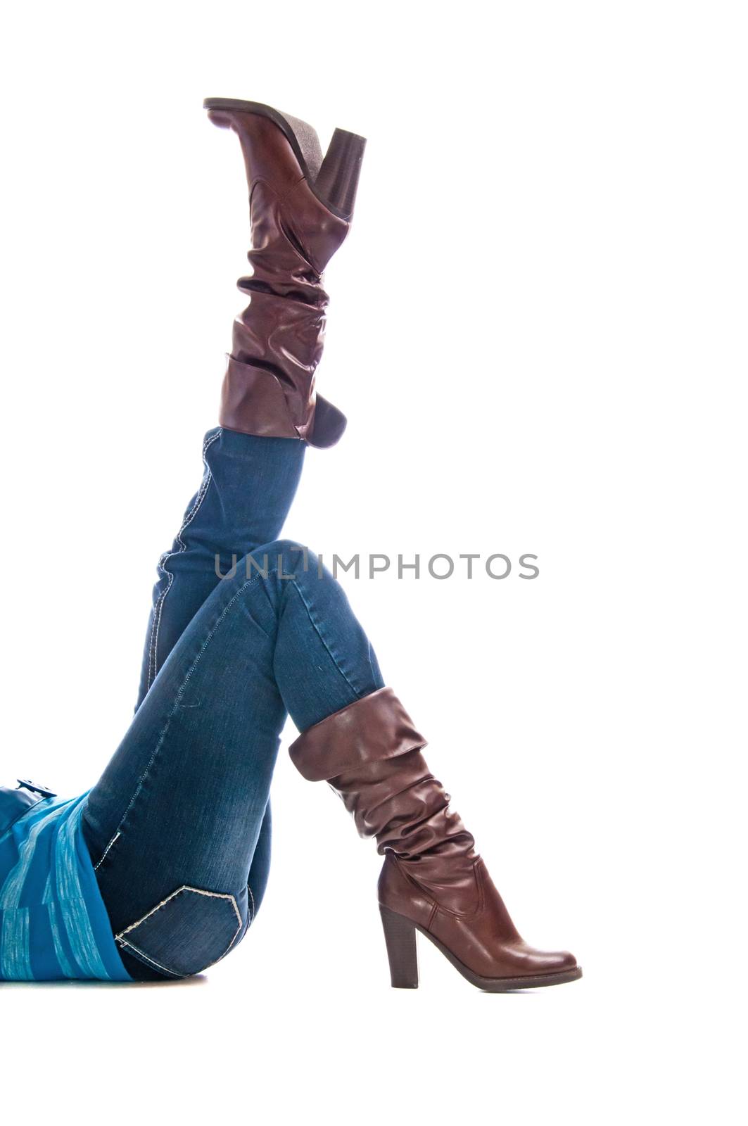 Woman in jeans on her back and one foot in the air. Isolated on a white background