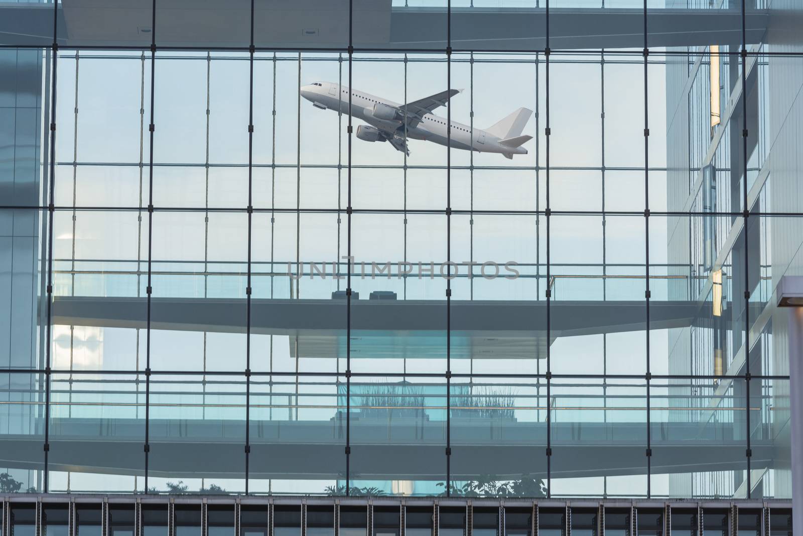 Modern office building with glass facade in the background a plane when you start.