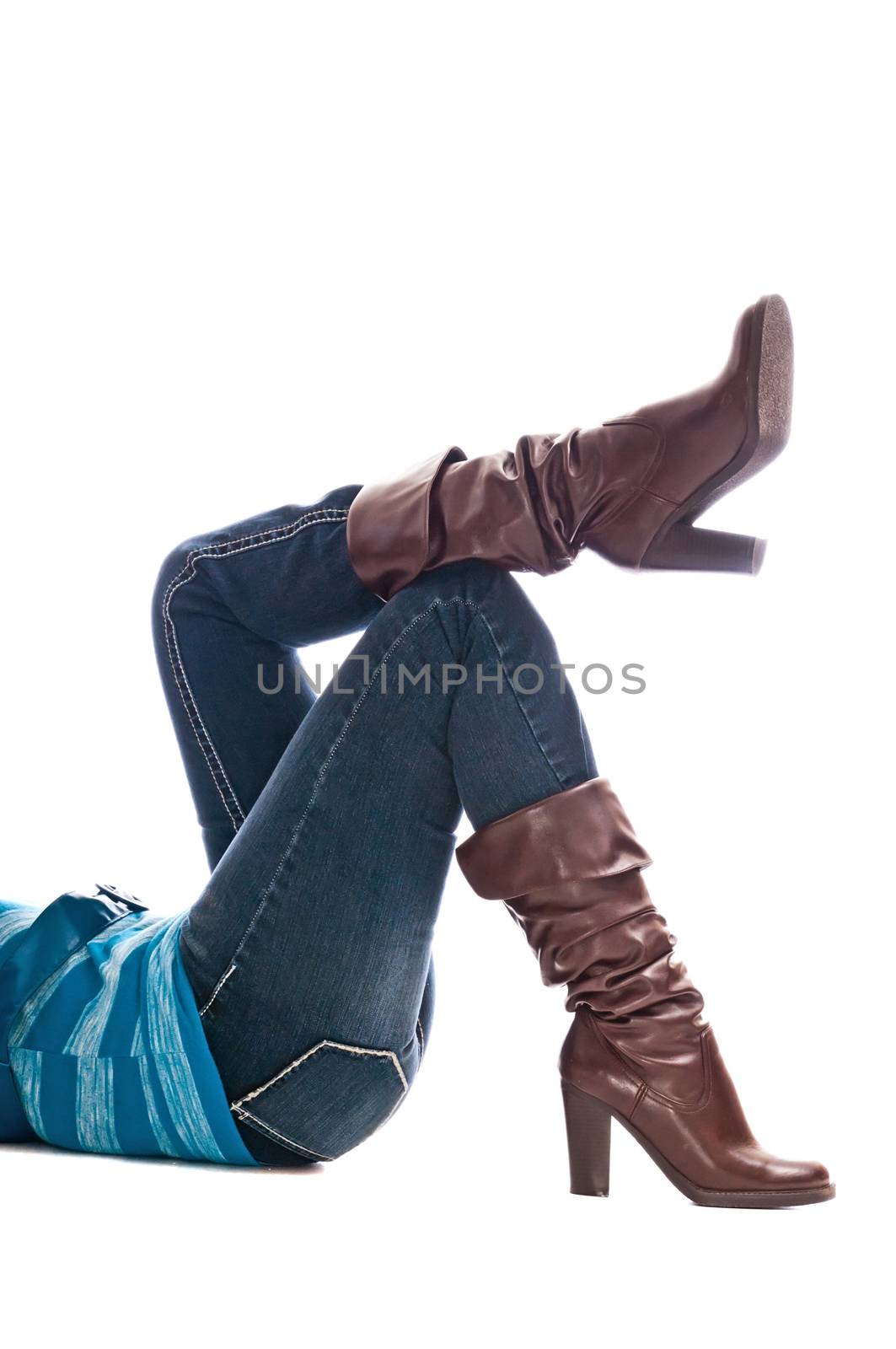 Shapely woman legs with fashion boots over denim jeans