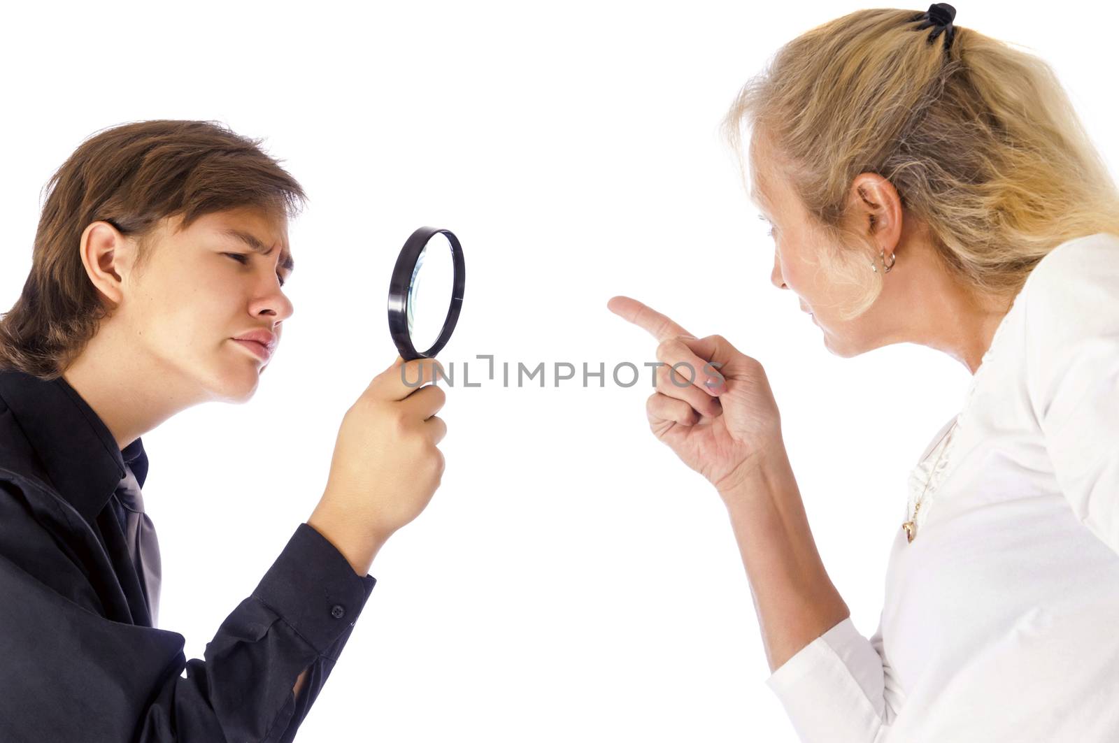 Teenage boy indifferent to his mothers scolding inspecting her finger as she points it at him.