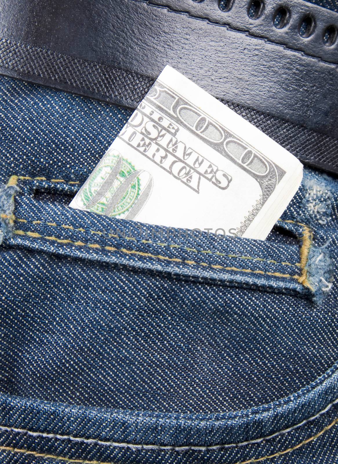 Stack of dollar bills in jeans pocket