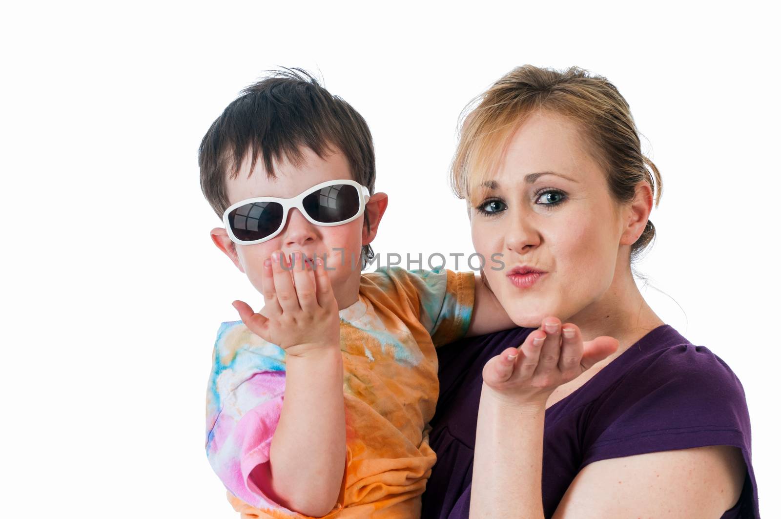Pretty young woman holding a three year old boy blowing kisses.