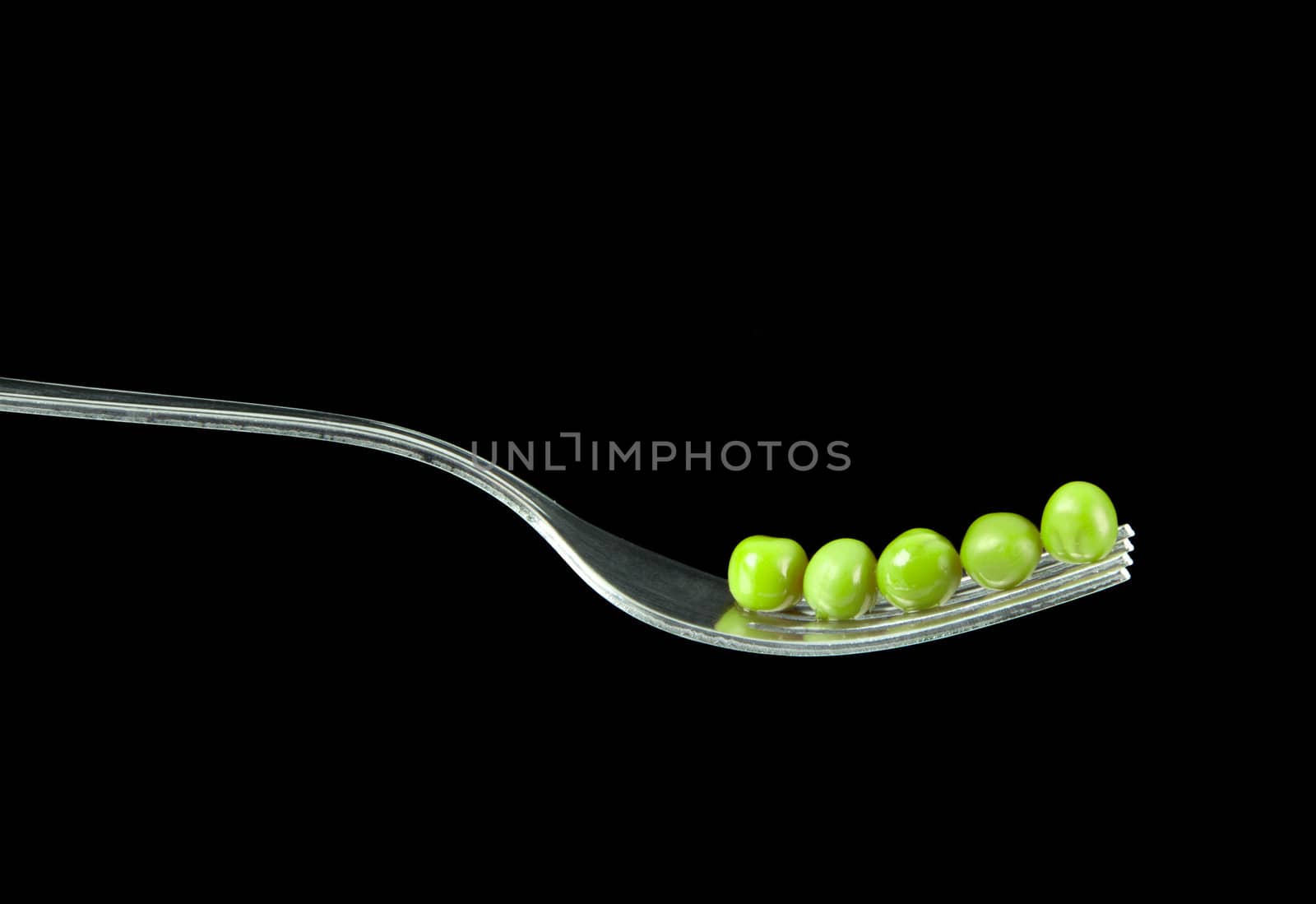 Fresh green peas on a silver fork