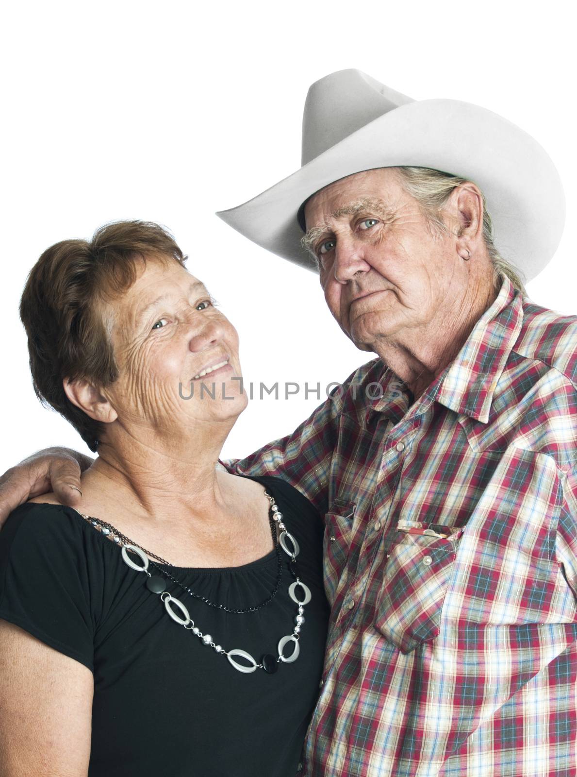 Elderly couple posing for an anniverary photo, arms around each other.