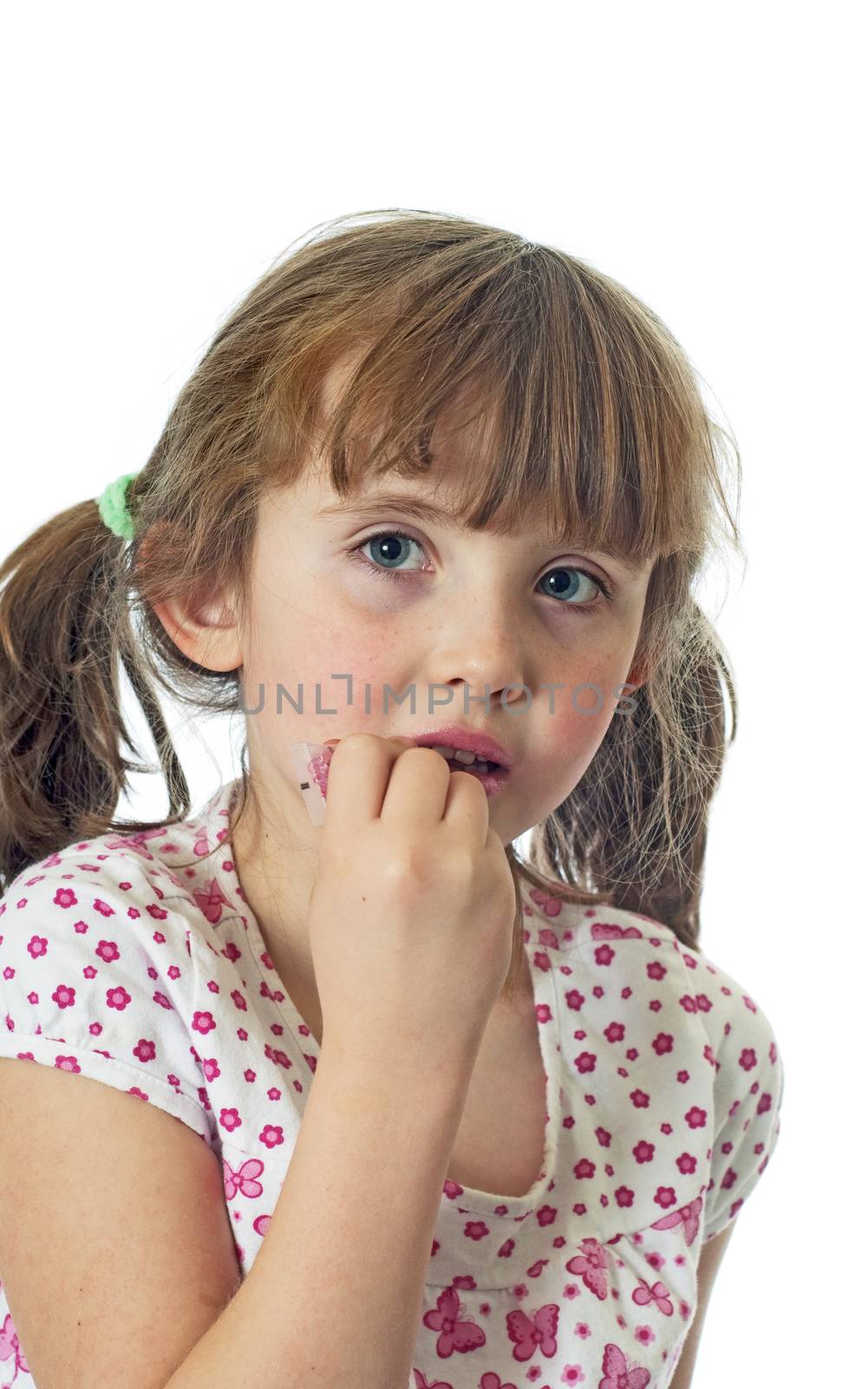 A little girl putting on lip gloss