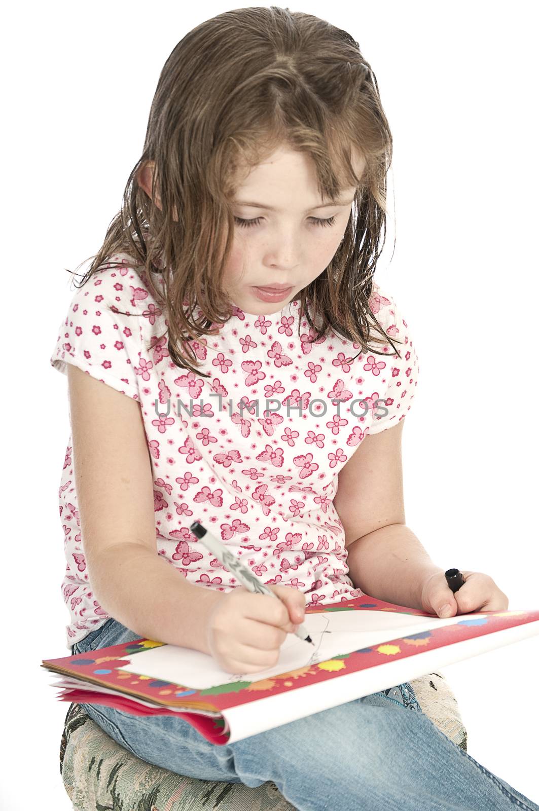 Little girl drawing on a sketchpad.