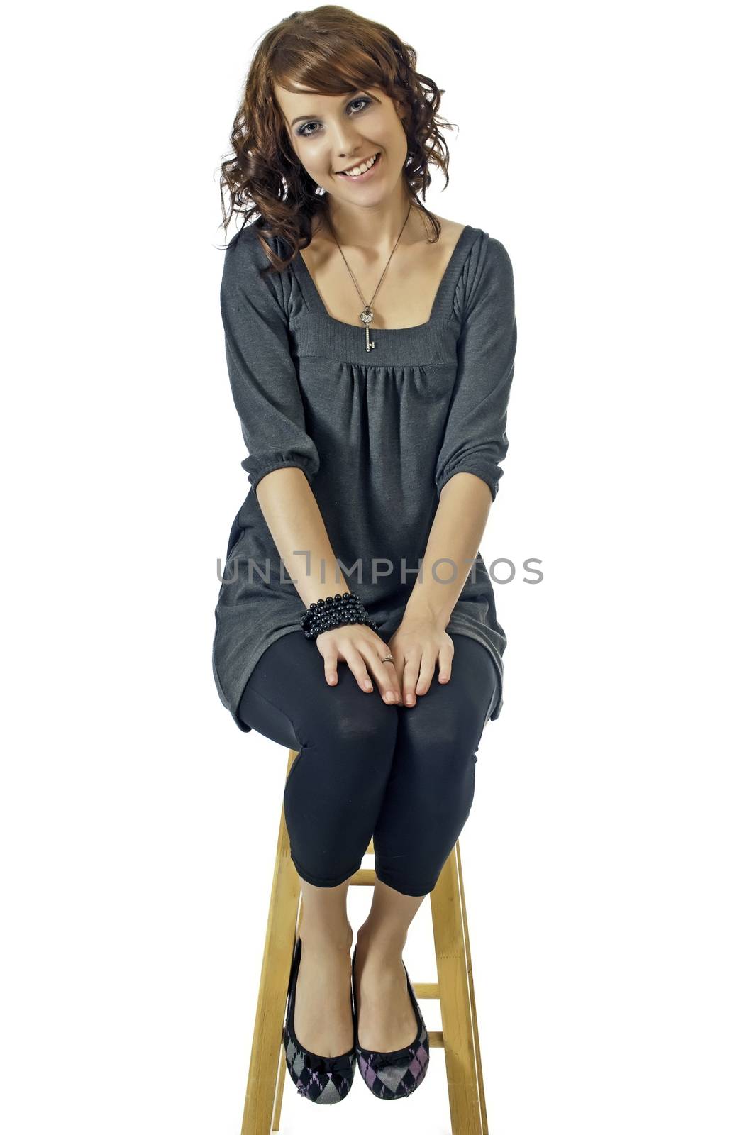 Smiling girl seated on a stool during an interview or audition for a movie part.