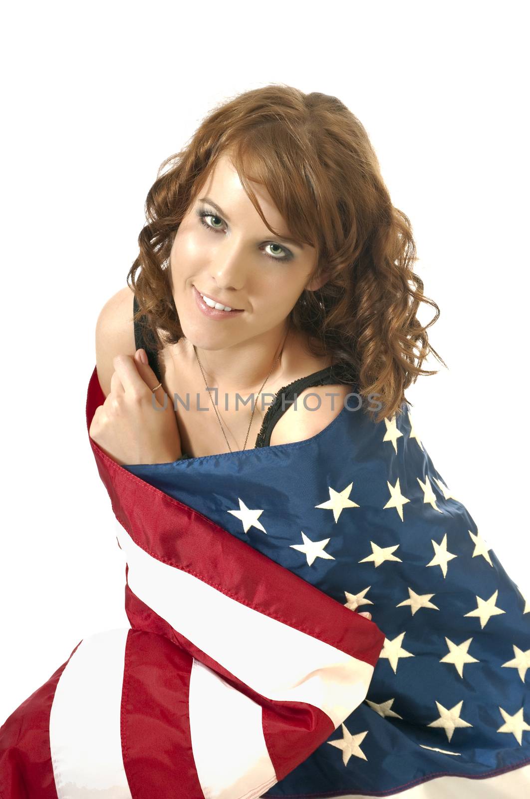 Pretty young woman wrapped in an American flag showing her 4th of July spirit and patriatisim.