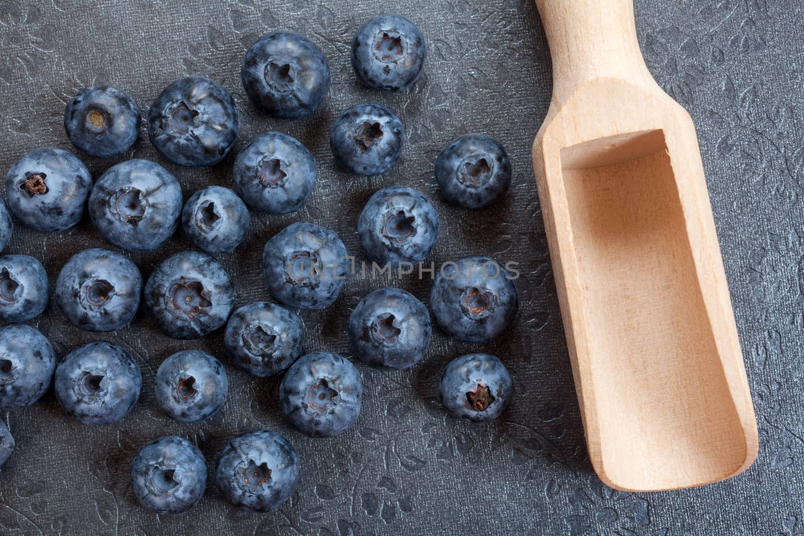 Blueberry in scoop on wooden table background