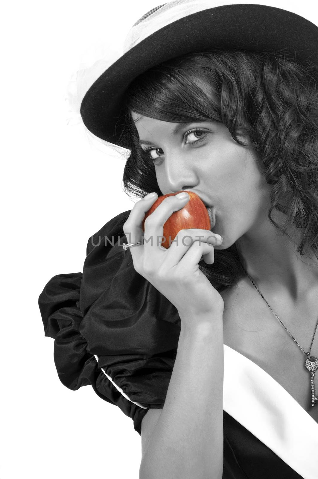 Pretty young woman taking a bite from a red apple. Black and White image with a Red apple.