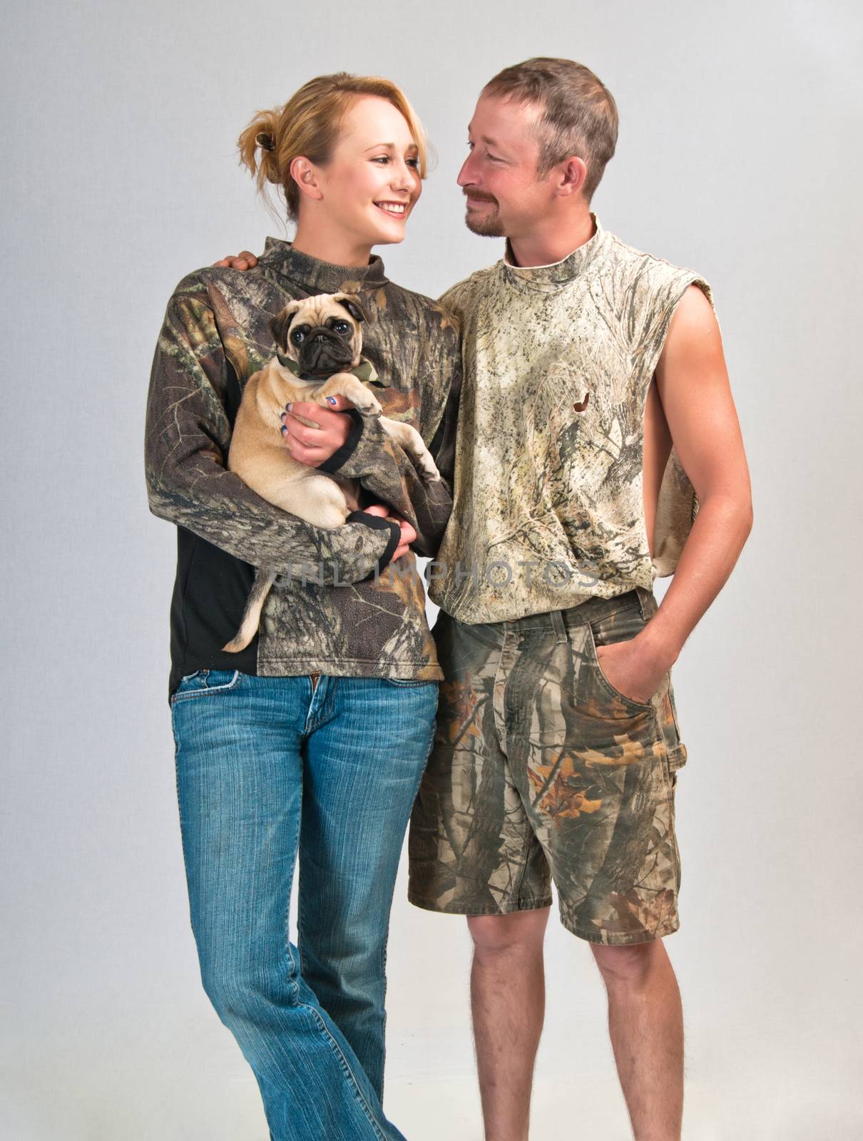 Happy couple after bringing home a pet Pug from the local animal shelter.